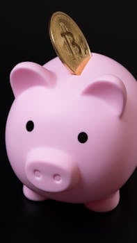 Pink piggy bank with a Bitcoin coin inserted, symbolizing digital savings and investment.